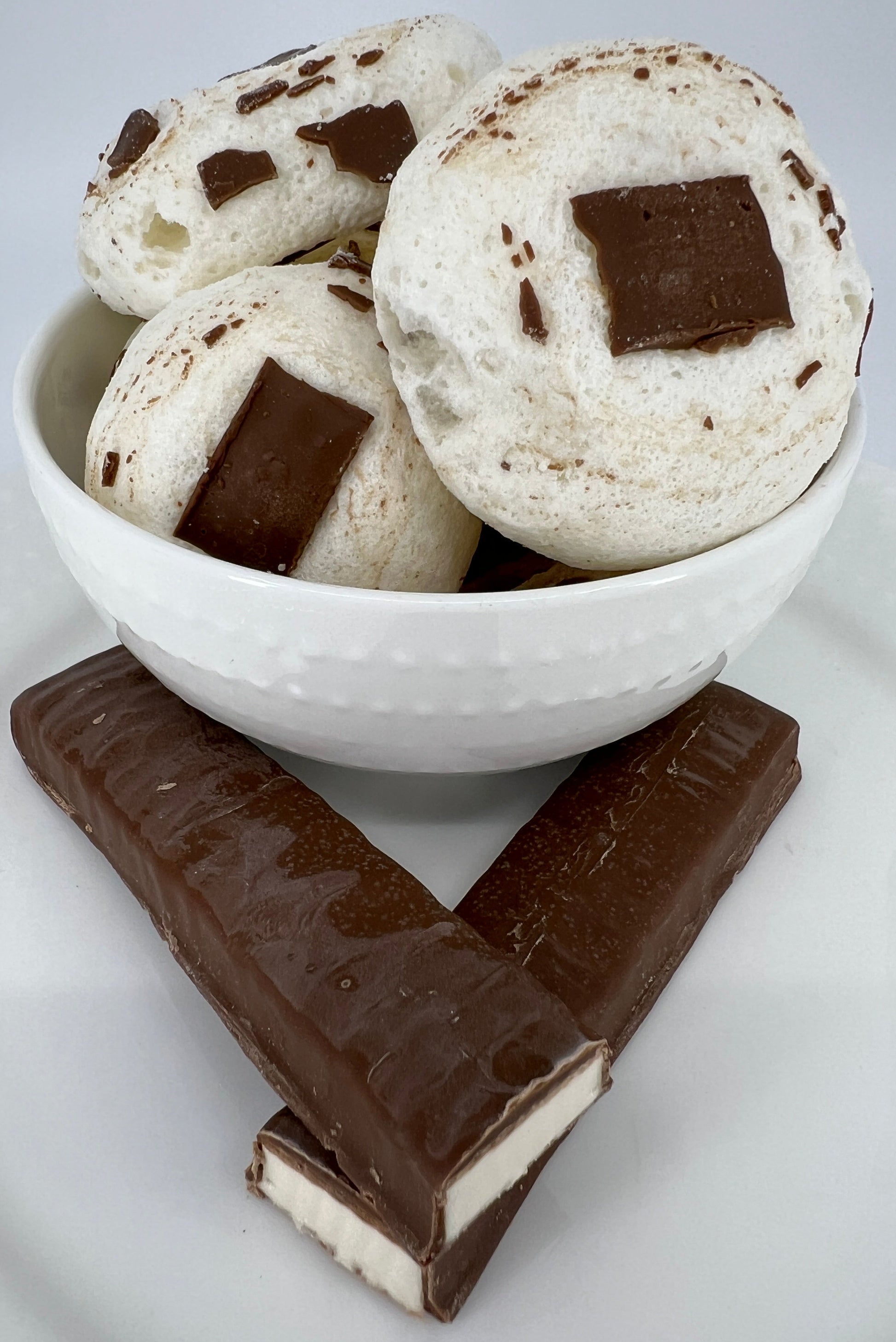 Chocolate-dipped cookies in a white bowl on a white plate